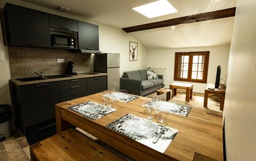 una cocina con una mesa con copas de vino. en Hôtel Le Coq d'Or en Les Angles