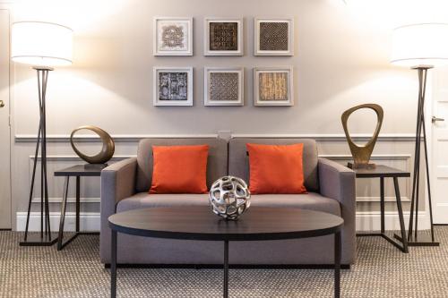 a living room with a couch and two tables at Crowne Plaza Fredericton Lord Beaverbrook by IHG in Fredericton