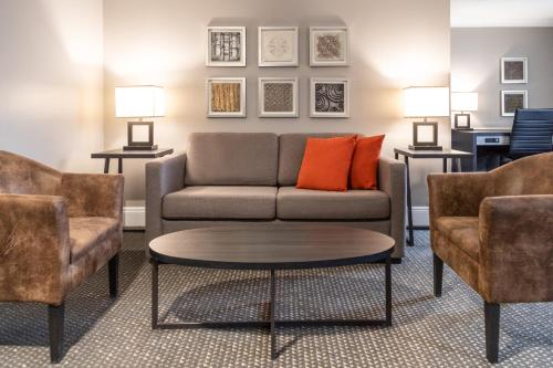 a living room with a couch and two chairs at Crowne Plaza Fredericton Lord Beaverbrook by IHG in Fredericton