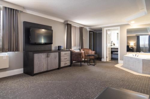 a hotel room with a tub and a television and a bathroom at Crowne Plaza Fredericton Lord Beaverbrook by IHG in Fredericton