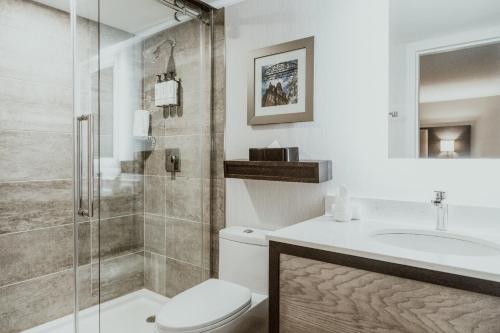 a bathroom with a shower and a toilet and a sink at Crowne Plaza Fredericton Lord Beaverbrook by IHG in Fredericton