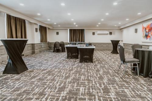 a conference room with tables and chairs and a stage at Crowne Plaza Fredericton Lord Beaverbrook by IHG in Fredericton