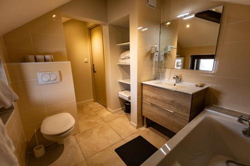 a bathroom with a toilet and a sink and a tub at Hôtel Le Coq d'Or in Les Angles