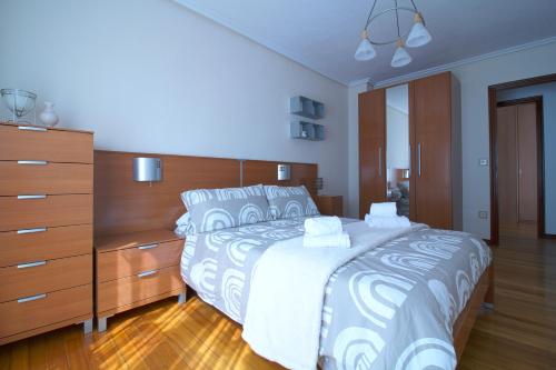 um quarto com uma cama grande e uma cómoda em Apartamento Brisa Marina em Suances