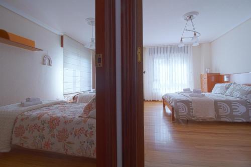 - une chambre avec deux lits et une chambre avec un lit dans l'établissement Apartamento Brisa Marina, à Suances