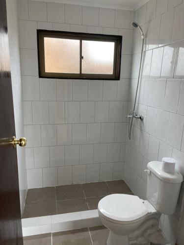 a bathroom with a toilet and a window at Cabañas La Herradura in Coquimbo