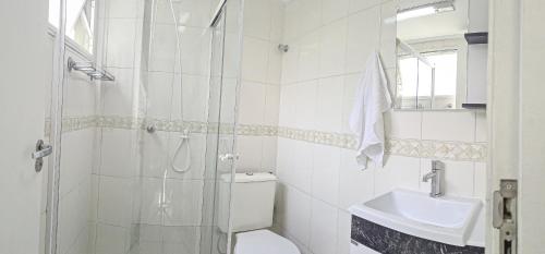 uma casa de banho com um chuveiro, um WC e um lavatório. em Studio Central Curitiba em Curitiba