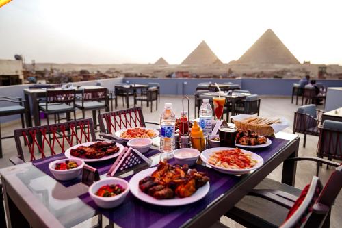 a table with dishes of food on top of a pyramid at Pyramids Inn in Cairo