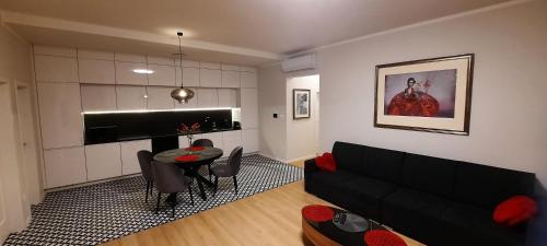 a living room with a black couch and a table at Apartmán B3 Turčianske Teplice in Turčianske Teplice