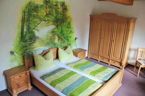 1 dormitorio con 1 cama con una pintura en la pared en Pension Zumpe en Stolpen
