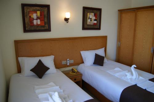 En eller flere senger på et rom på Palm Inn City Hotel