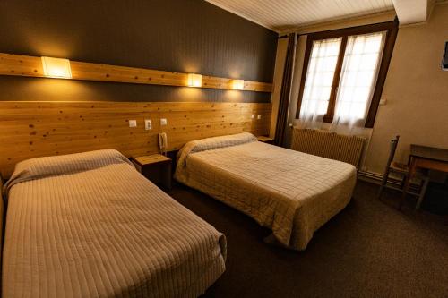 Posteľ alebo postele v izbe v ubytovaní Hôtel Le Coq d'Or