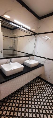 two sinks in a bathroom with black and white tiles at Apartmán B3 Turčianske Teplice in Turčianske Teplice
