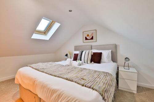 Un dormitorio con una gran cama blanca y una ventana en StayRight 3 Bed House with Private Parking, en Cardiff