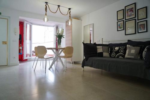 sala de estar con sofá, mesa y sillas en Apartamento Ágüelos, en Madrid
