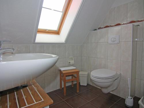 La salle de bains est pourvue d'un lavabo, de toilettes et d'une lucarne. dans l'établissement Apartment house, Trassenheide, à Trassenheide
