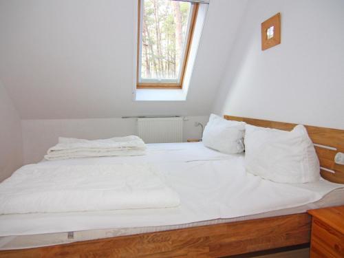 - une chambre avec un lit doté de draps blancs et une fenêtre dans l'établissement Apartment house, Trassenheide, à Trassenheide