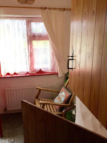 una silla en una habitación con ventana en Mask Cottage en Partry