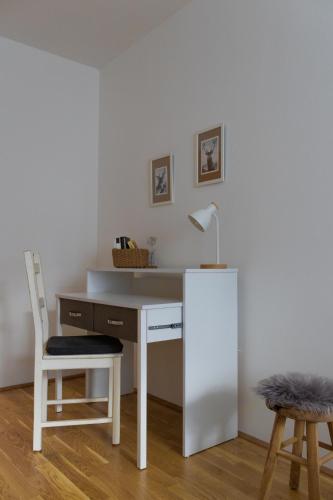 a white desk with a chair and a white refrigerator at Danube City Lodge, uptown, A/C in Vienna