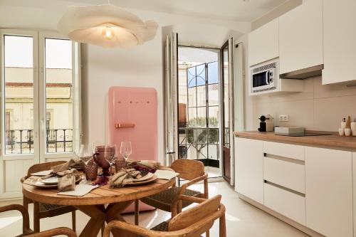 een keuken met een tafel met stoelen en een roze koelkast bij LUPERCAS in Merida