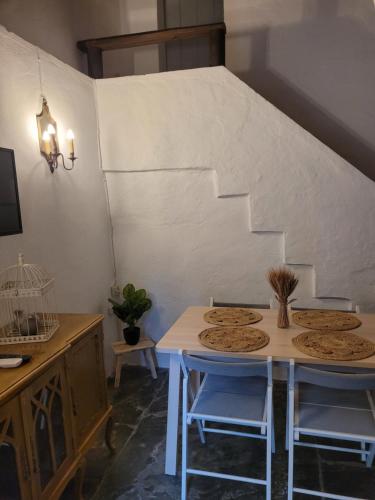 Pokój ze stołem, krzesłami i schodami w obiekcie Casa Tia Anica w mieście Reguengos de Monsaraz