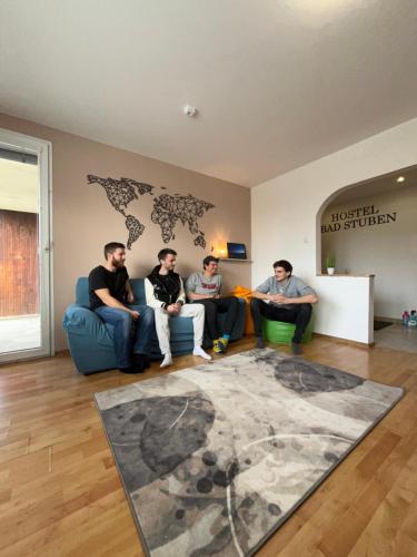 a group of men sitting in a living room at Bad Stuben Hostel in Turčianske Teplice