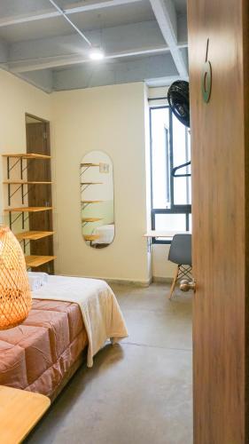 a bedroom with a bed and a desk in a room at Selva House in Medellín