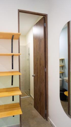 a bathroom with a mirror and a wooden door at Selva House in Medellín