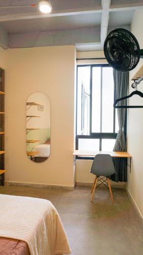 a bedroom with a bed and a mirror and a chair at Selva House in Medellín