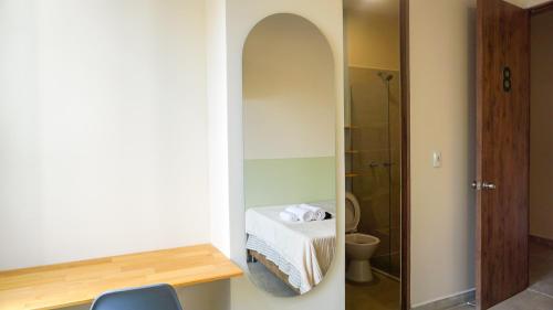 een kleine badkamer met een toilet en een spiegel bij Casa Selva in Medellín