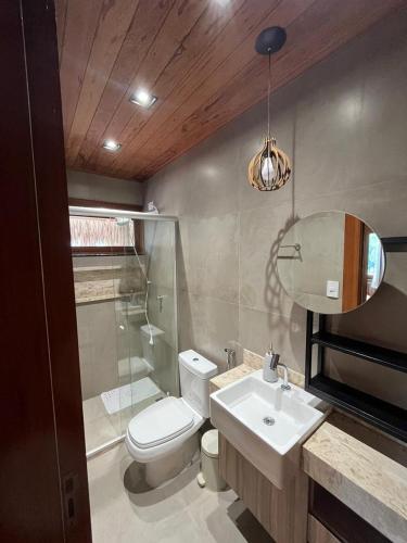 a bathroom with a toilet and a sink and a mirror at Vila Tamarindo (Bangalô 6) in Barra Grande
