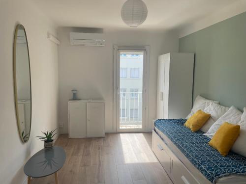 - une chambre avec un lit doté de draps bleus et d'oreillers jaunes dans l'établissement Le Mercier - T3 climatisé avec balcon, à Sète