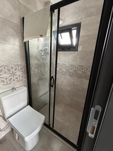 a bathroom with a toilet and a glass shower at The North Cunda in Cunda