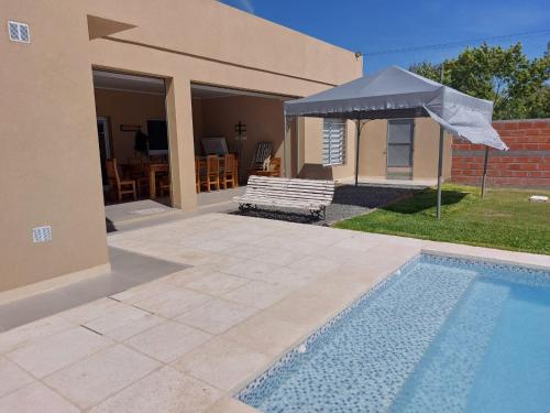 a house with a swimming pool and an umbrella at Casa Quinta LA ESQUINA in Olivera
