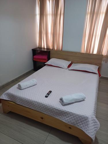 a bed with two pillows on it in a bedroom at APARTAMENTO FAMILIA CAFETERA in Santa Rosa de Cabal