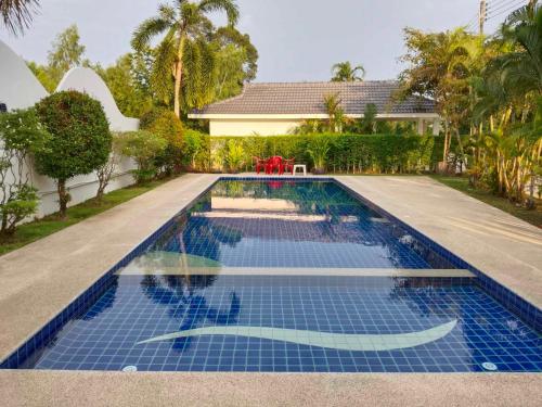 a swimming pool with blue tiles in a house at F&F Mae Phim Villa Rayong in Ban Ang