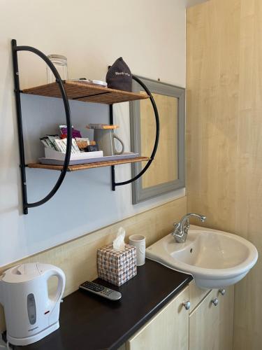 een badkamer met een wastafel en een spiegel bij Rivendell Guest House in Keswick
