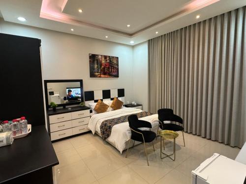 1 dormitorio con 1 cama, 2 sillas y TV en استوديو غرفة ودورة مياه 5, en Riad