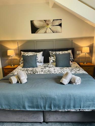 a bedroom with a large bed with two pillows at Rivendell Guest House in Keswick