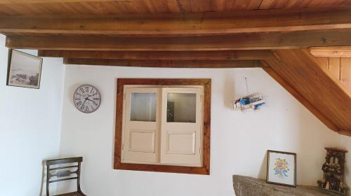a room with a door and a clock on the wall at Orion Guesthouse Telhado in Fundão