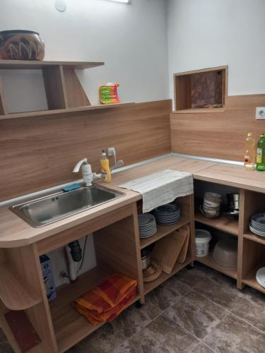 eine Küche mit einer Spüle und Holzschränken in der Unterkunft Къща за гости АлеЯ in Kranewo