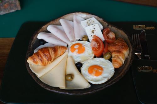 a plate of food with eggs and bread and croissants at Hotel Sumadija in Belgrade
