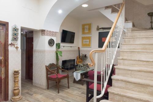 sala de estar con escaleras y chimenea en Casa de la Judería Doña Pilar en Sevilla