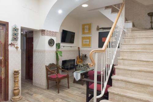 sala de estar con escaleras y chimenea en Casa de la Judería Doña Pilar, en Sevilla