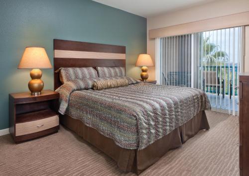 1 dormitorio con 1 cama grande y balcón en Worldmark Oceanside Harbor, en Oceanside