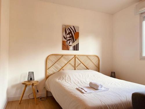 a bedroom with a bed with a towel on it at Appartement proche Centre-ville in Saint Lo
