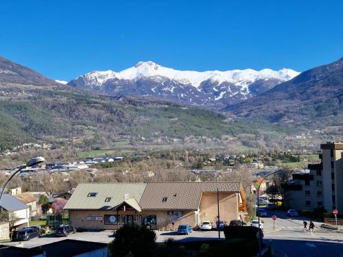 a view of a town with mountains in the background at Les Campanules du rivage in Embrun