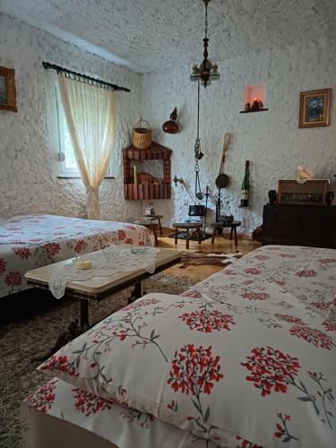 a bedroom with two beds and a table in it at Sailor's Rustic House in Virpazar