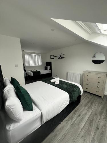a bedroom with a large bed and a living room at Central Location Liverpool, Modern Home, 4 BR, Sleeps 9, Free Parking in Liverpool