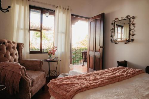 - une chambre avec un lit, une chaise et un miroir dans l'établissement Autumn in Antigua Boutique Hotel, à Antigua Guatemala